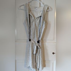 Small, sleeveless printed dress with tassel and waist tie.